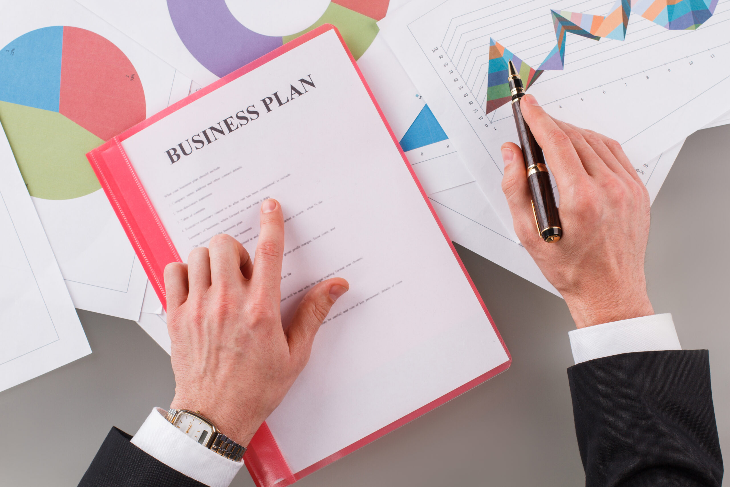 Businessman point to the graph of the company financial statements in the paperwork